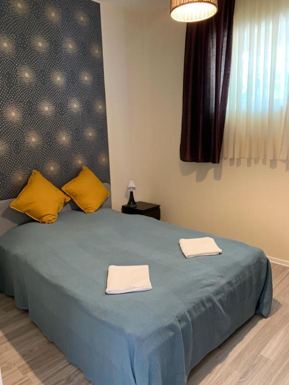 1 dormitorio con 1 cama azul y 2 toallas en Bazsalikom Vendégház, en Sárospatak