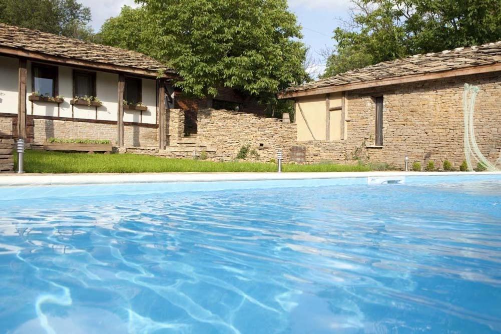 a large blue swimming pool next to a building at The Four Houses in Kostenkovtsi