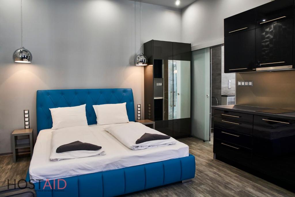 1 cama con cabecero azul en una habitación en A13 Apartments - Budapest - hostAID en Budapest