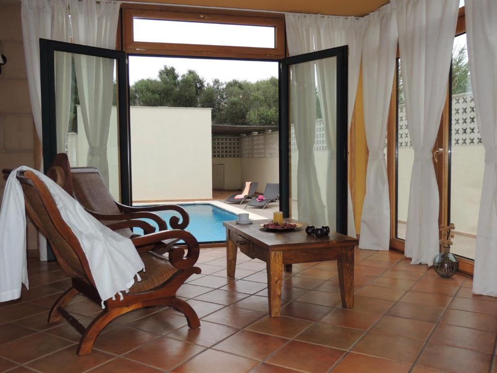 un soggiorno con sedia, tavolo e piscina di Villa Ca Na Llum a Trebeluger
