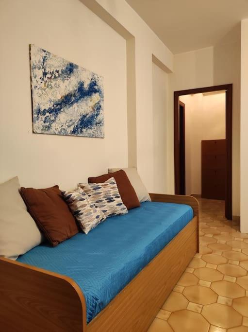 sypialnia z łóżkiem z niebieską pościelą i obrazem w obiekcie Sweet House w mieście Fondachello