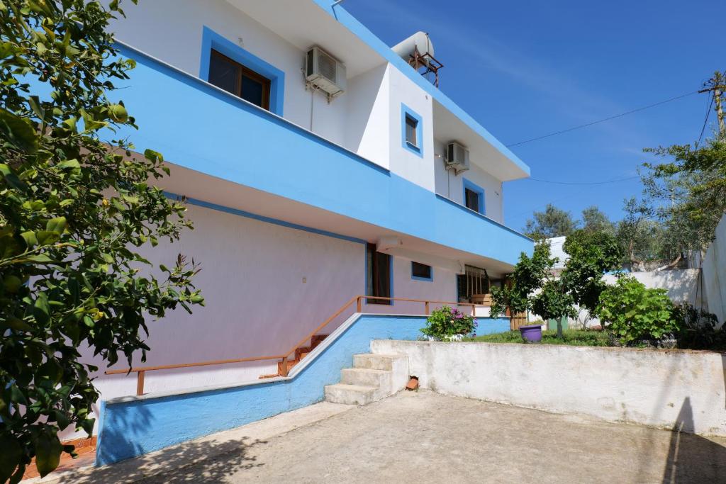 ein Haus mit einer blauen Treppe davor in der Unterkunft Vila Ronaldo in Ksamil