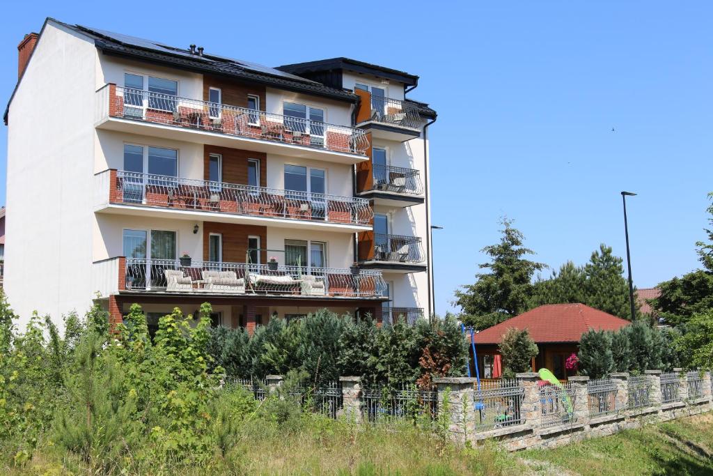 un edificio de apartamentos con balcones y una valla en Pokoje gościnne Dawid, en Władysławowo