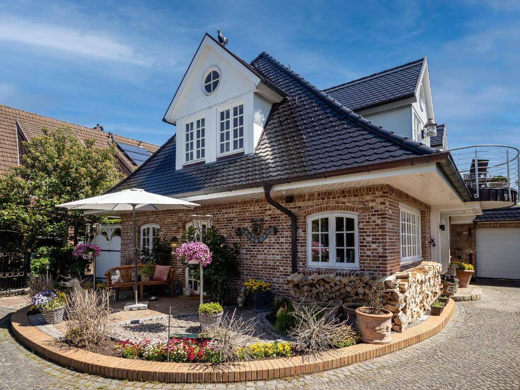 een stenen huis met een paraplu op een binnenplaats bij Südwind´s Fischerkoje in Westerland