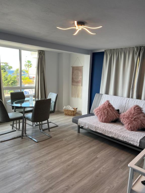 a living room with a couch and a table with chairs at CORNELIAS HOME TC1 playa in Los Cristianos