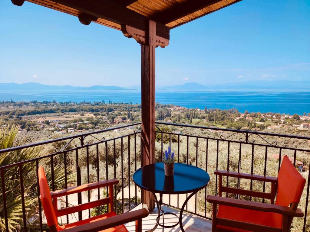 a patio with two chairs and a table on a balcony at Sun Touch Pelion Rooms in Kala Nera