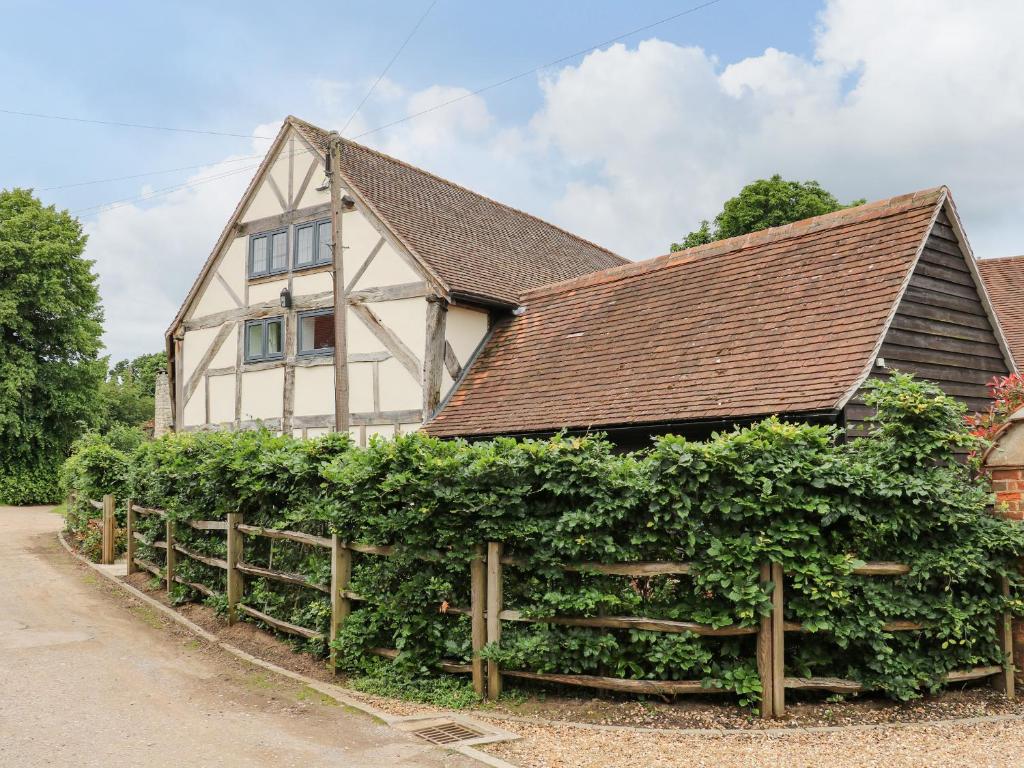 a house with a hedge in front of it at 2 Great Tangley Barns in Guildford