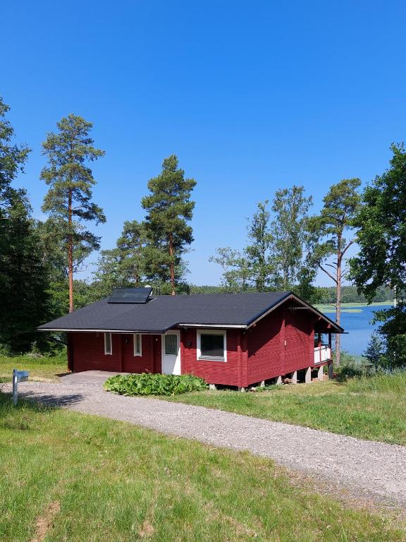 a red house on the side of a field at Uttis Home in Nauvo