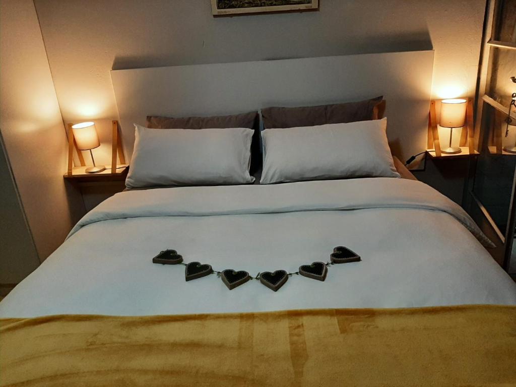 a bed with two hearts on it with two lamps at UppaTree Cottage in Benoni