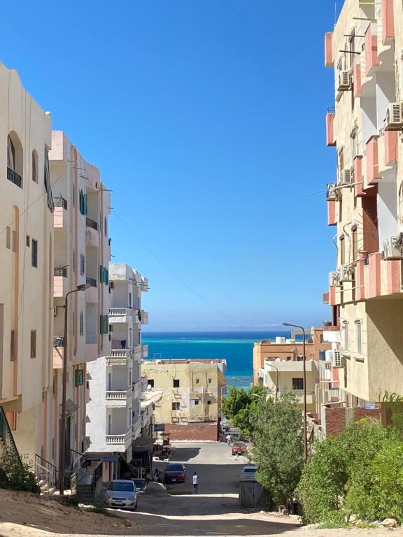 una calle de la ciudad con edificios y el océano en el fondo en PORTO HILL, en Hurghada