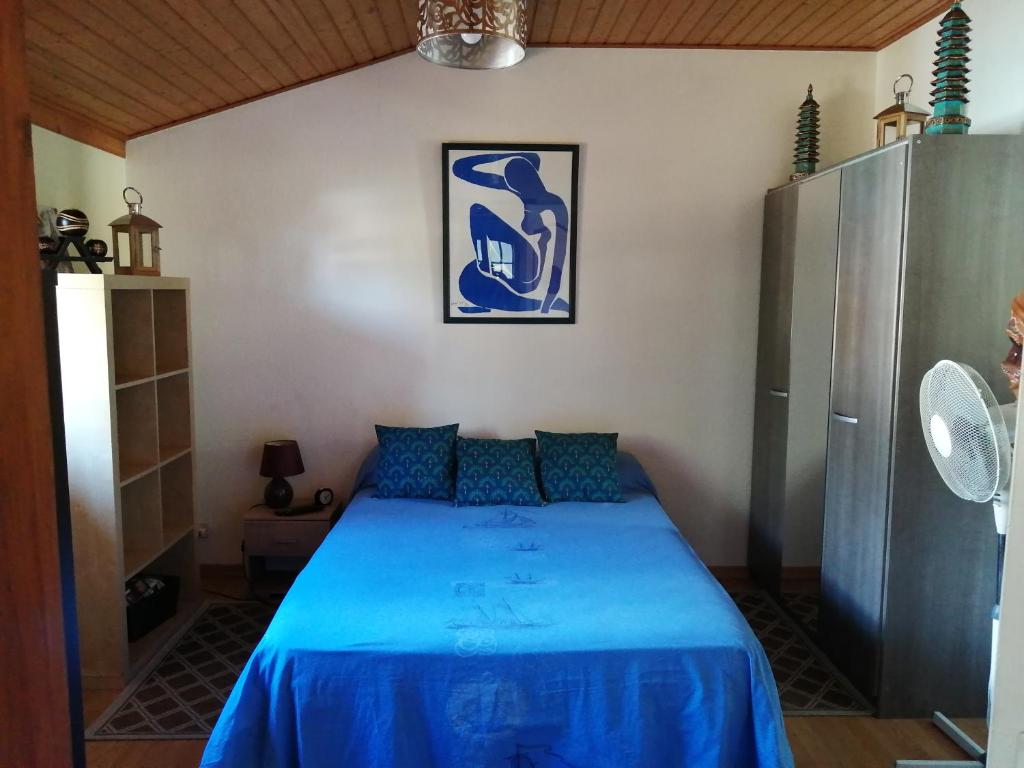 a bedroom with a blue bed in a room at Joli appartement très clair in Le Verdon-sur-Mer