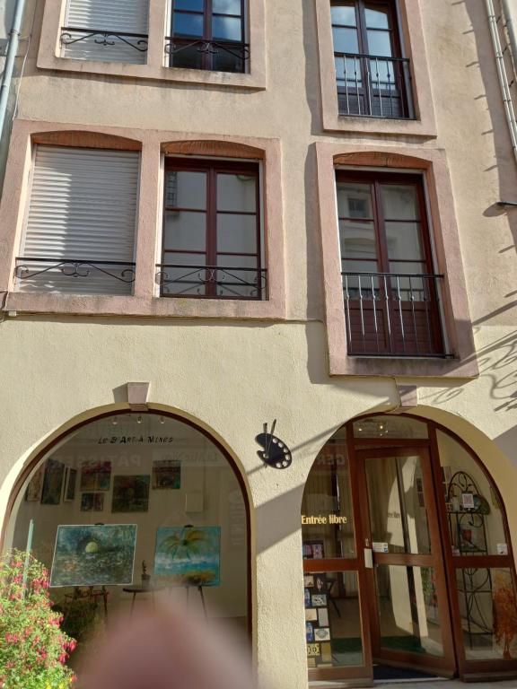 a building with arched doors and windows at Meublé de tourisme L'Eau Vive classé 2 étoiles in Plombières-les-Bains