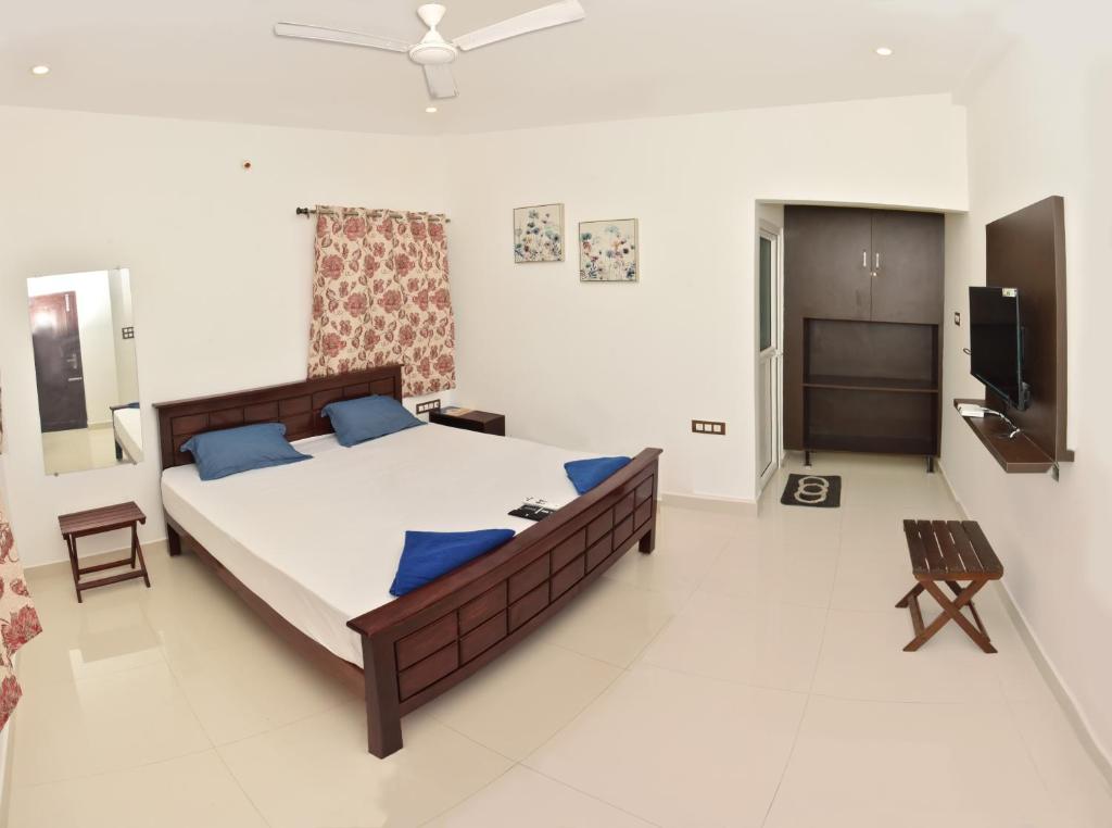 a bedroom with a large bed with blue pillows at Catch A Wave in Mahabalipuram