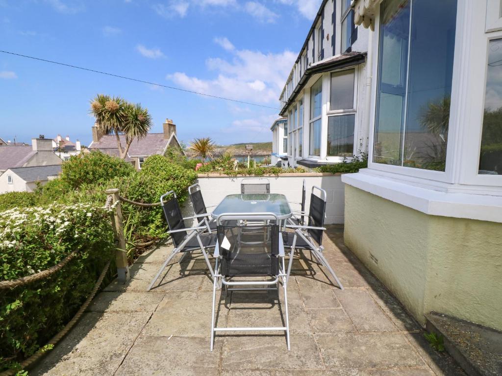a table and chairs on the balcony of a house at Gorphwysfa in Cemaes Bay