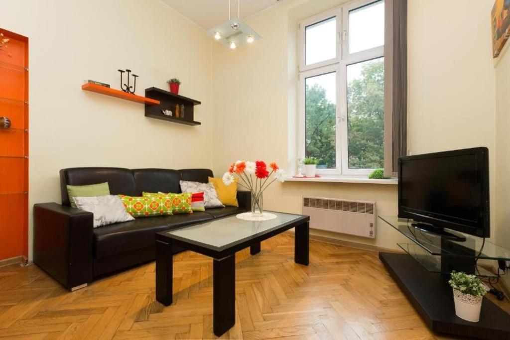 a living room with a black couch and a coffee table at Urban Nest Apartments Dietla 69-8B in Kraków