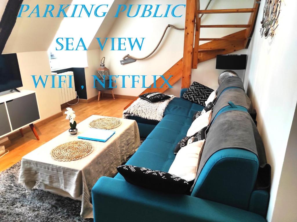 a living room with a blue couch and a table at Appartement Saint Malo vue sur mer et sur intra muros, Ferry, plage et commerces à 50 m in Saint Malo