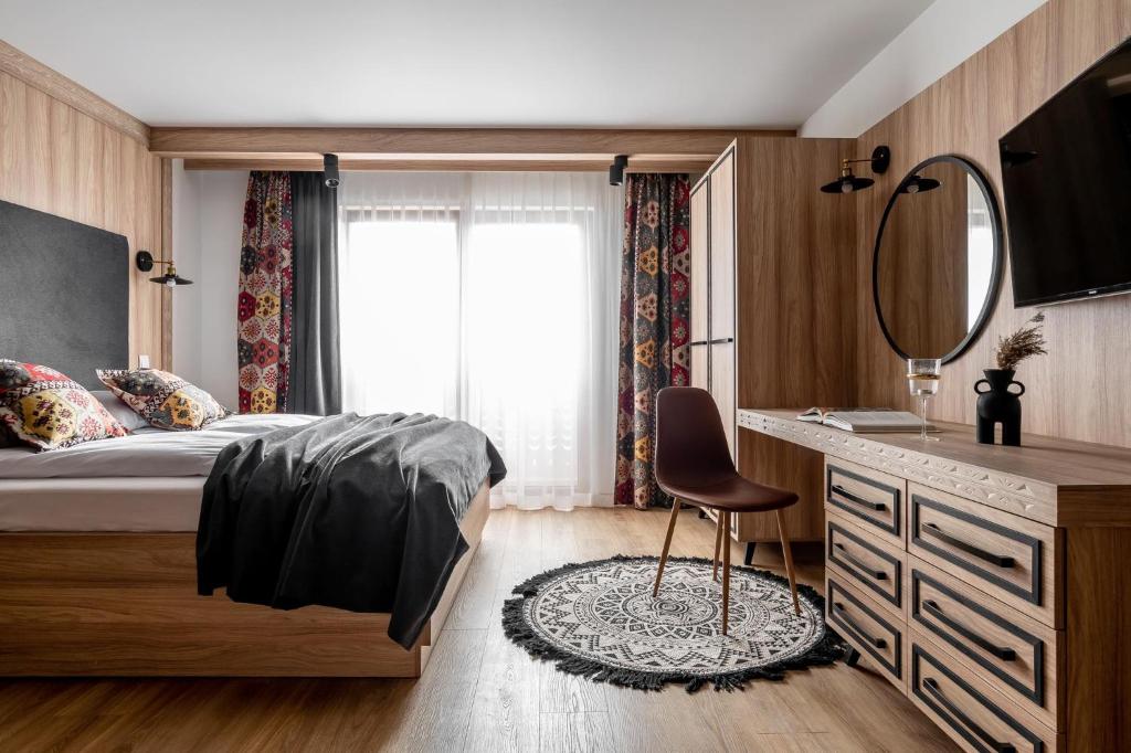 een slaapkamer met een bed, een spiegel en een wastafel bij Willa Dunajec - Luxury Apartments in Zakopane