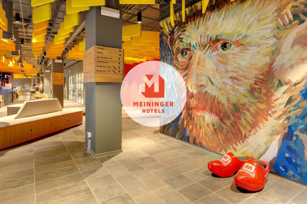 a store with a mural of a lion and red shoes at MEININGER Hotel Amsterdam City West in Amsterdam