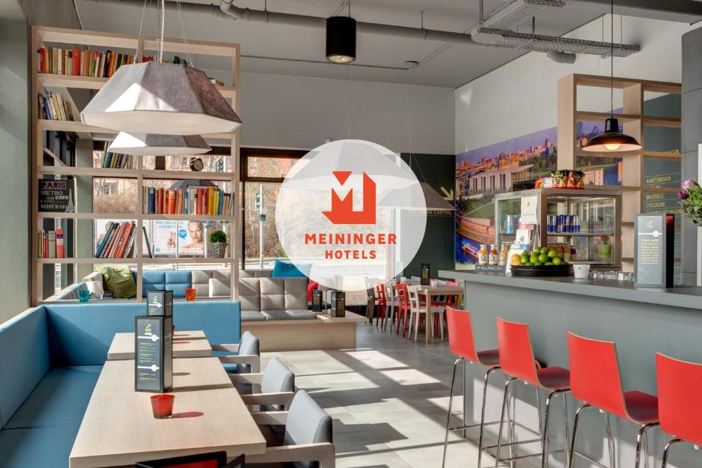 a restaurant with tables and chairs and a sign that reads member heroes at MEININGER Hotel Berlin Airport in Berlin