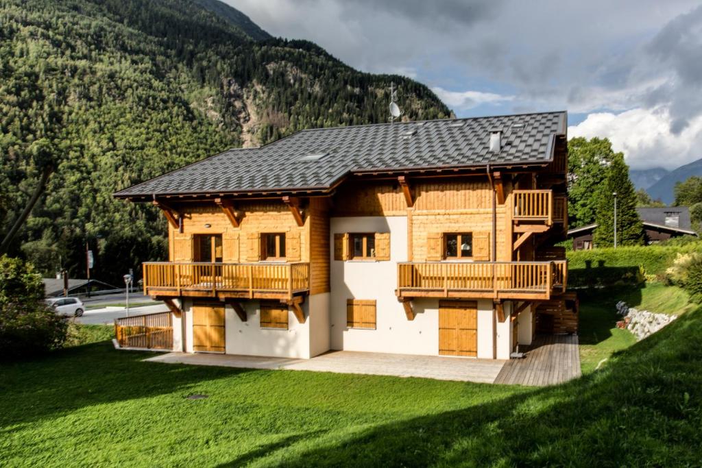 a wooden house with a balcony on a hill at Apartment Chalet des Granges in Les Houches