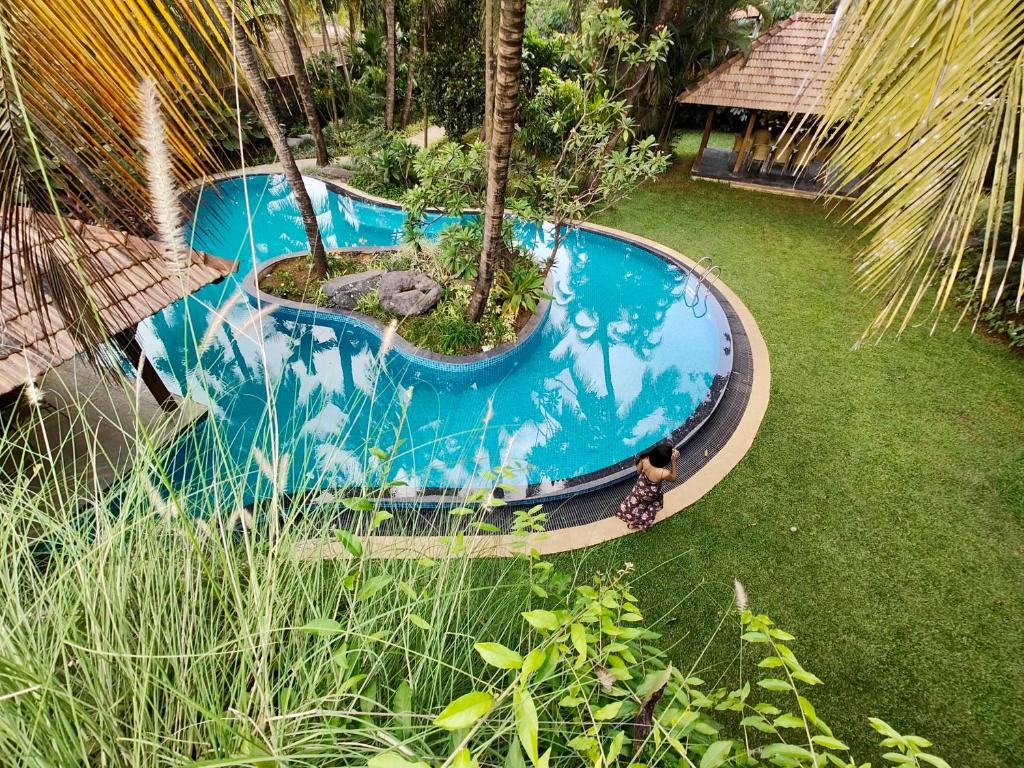 Una vista aérea de una piscina en un jardín. en SaffronStays Kimaya, Alibaug, en Alibaug