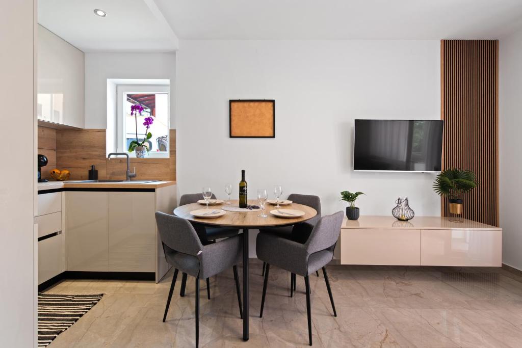 eine Küche und ein Esszimmer mit einem Tisch und Stühlen in der Unterkunft Apartment Masha in Novigrad Istria
