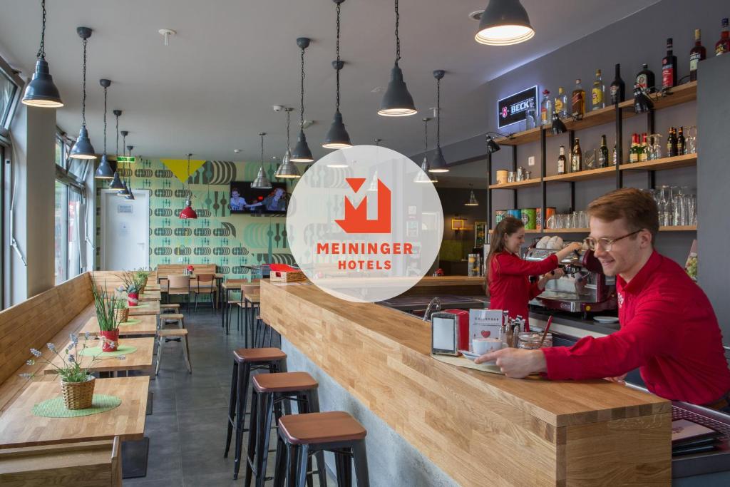 Een man aan een bar in een restaurant. bij MEININGER Hotel Berlin Alexanderplatz in Berlijn