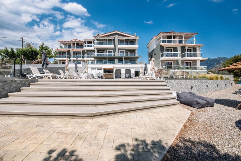 a large white building with stairs in front of it at Trizonia Bay Hotel in Trizonia