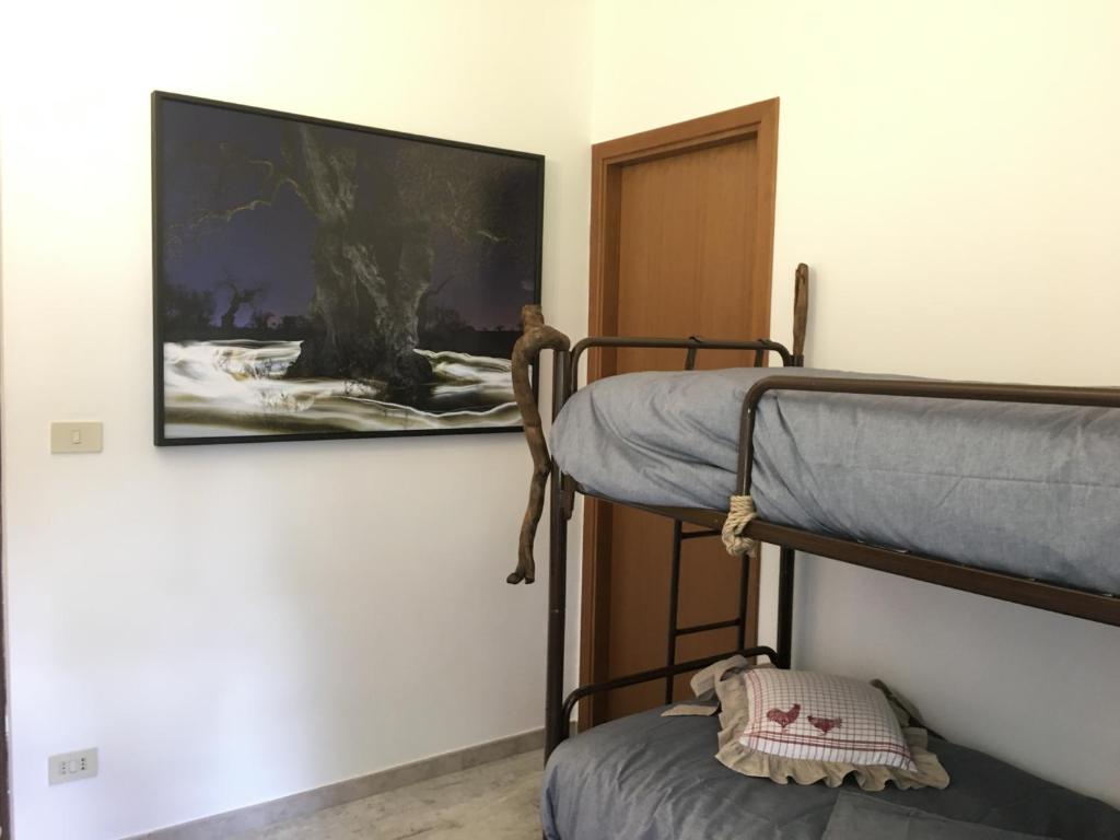 a room with two bunk beds and a tv on the wall at Garola Coccodè 2 in Luserna San Giovanni