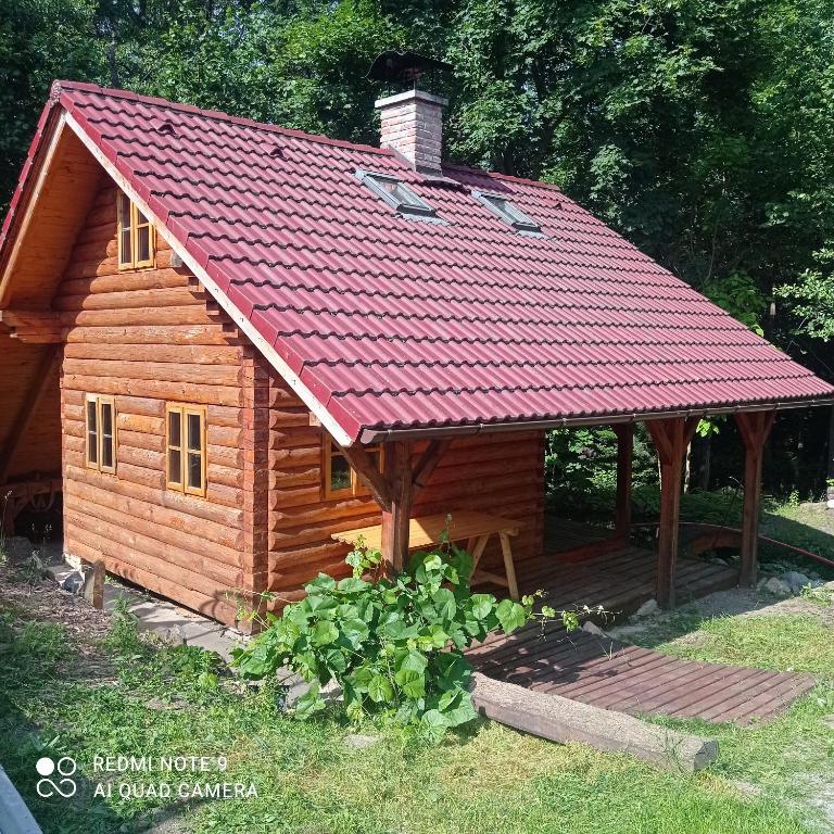 una baita di tronchi con tetto rosso di Chata Vidlák a Černíny