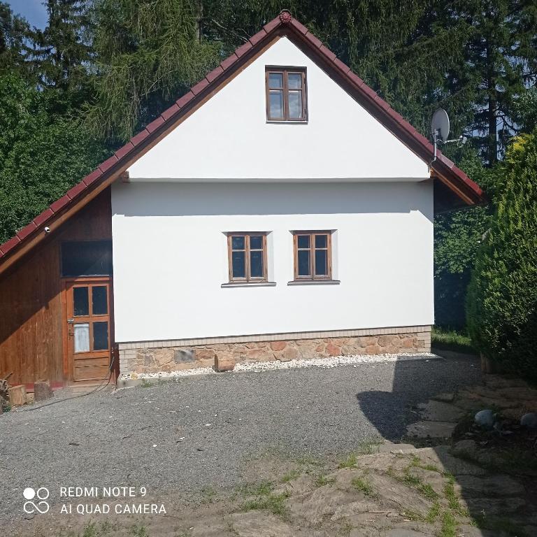 una casa bianca con tetto rosso di Chata Vidlák a Černíny