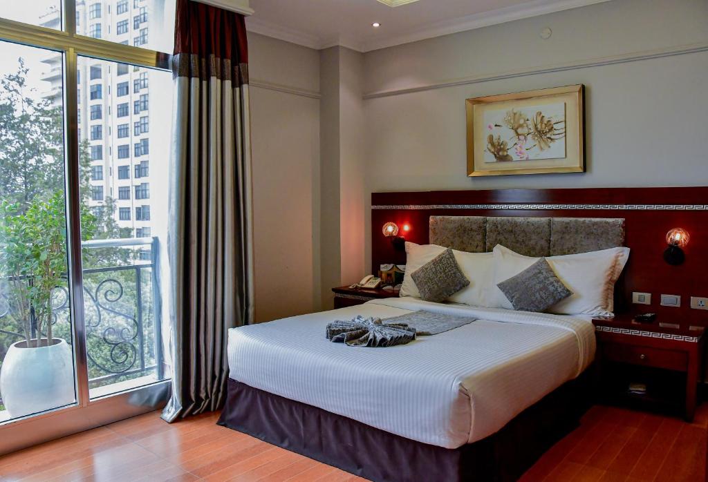 Cette chambre comprend un lit et une grande fenêtre. dans l'établissement Base Ethiopia International Hotel, à Addis-Abeba
