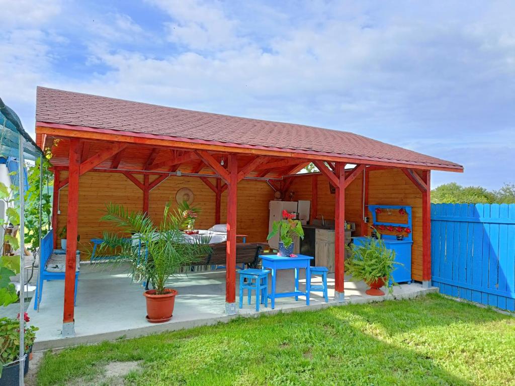 a wooden pavilion with tables and chairs in a yard at Casa NICHIFOR Jurilovca in Jurilovca