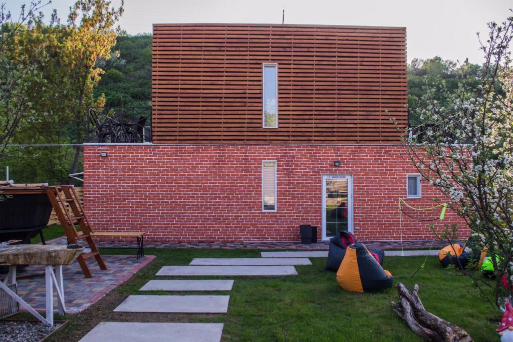 ein rotes Backsteingebäude mit vielen Kissen im Hof in der Unterkunft Nasha Dacha in Almaty