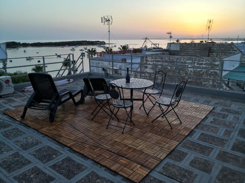 a patio with a table and chairs on a roof at Salento Sea & Sun Apartment in Porto Cesareo