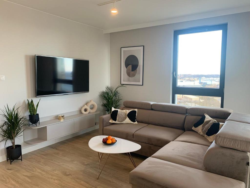 ein Wohnzimmer mit einem Sofa und einem Flachbild-TV in der Unterkunft Apartament Oficer Portova in Gdynia