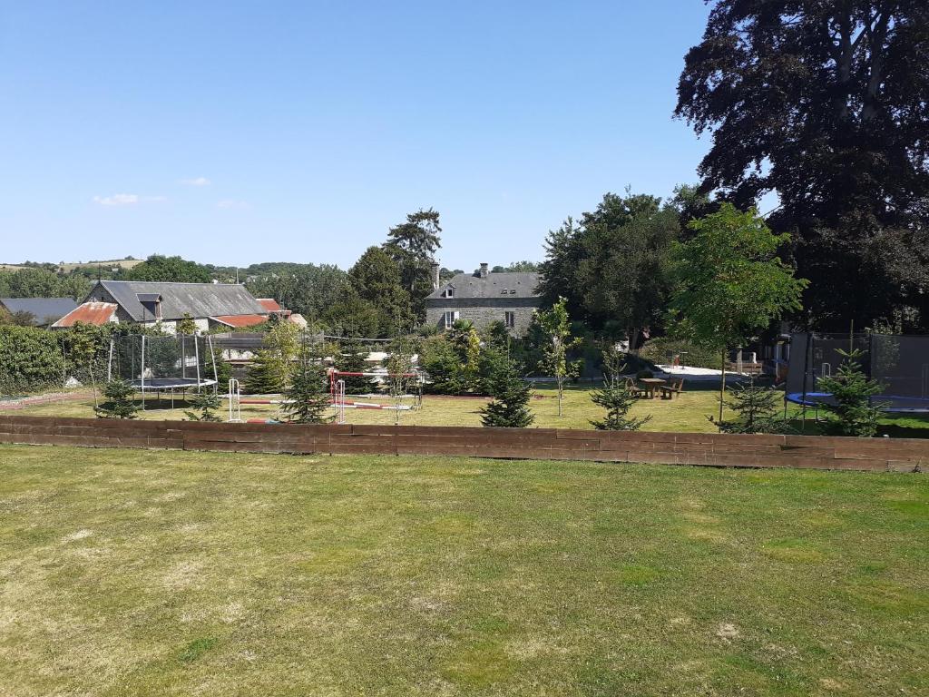 un jardin avec des arbres et une maison en arrière-plan dans l'établissement cottage, à Condé-sur-Noireau