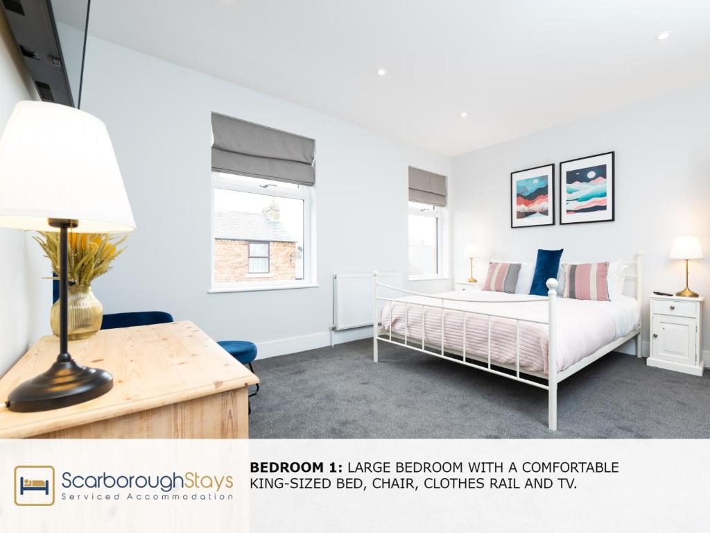 a bedroom with a bed and a desk with a lamp at Scarborough Stays - Trafalgar Lodge - 4 bedroomed house - Free Parking in Scarborough
