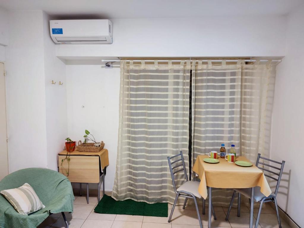 a dining room with a table and chairs and a window at Studio 7 - Hospital Italiano in Buenos Aires