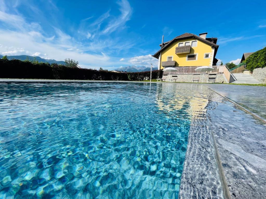 a house with a pool of water in front of it at Residence Tantalus in San Lorenzo di Sebato