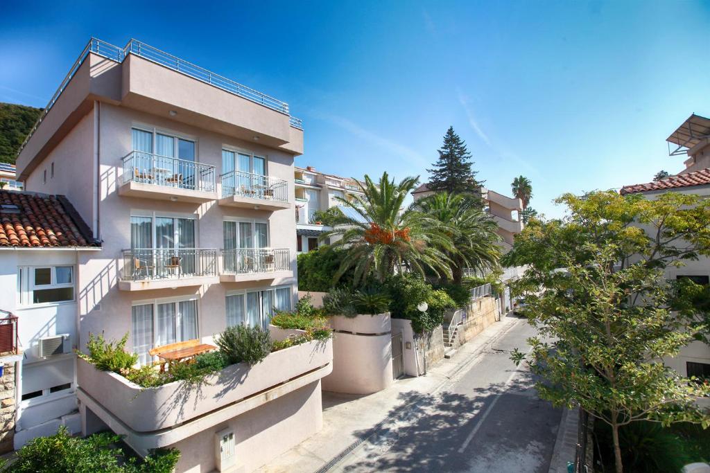 an apartment building with palm trees on a street at House Star in Petrovac na Moru