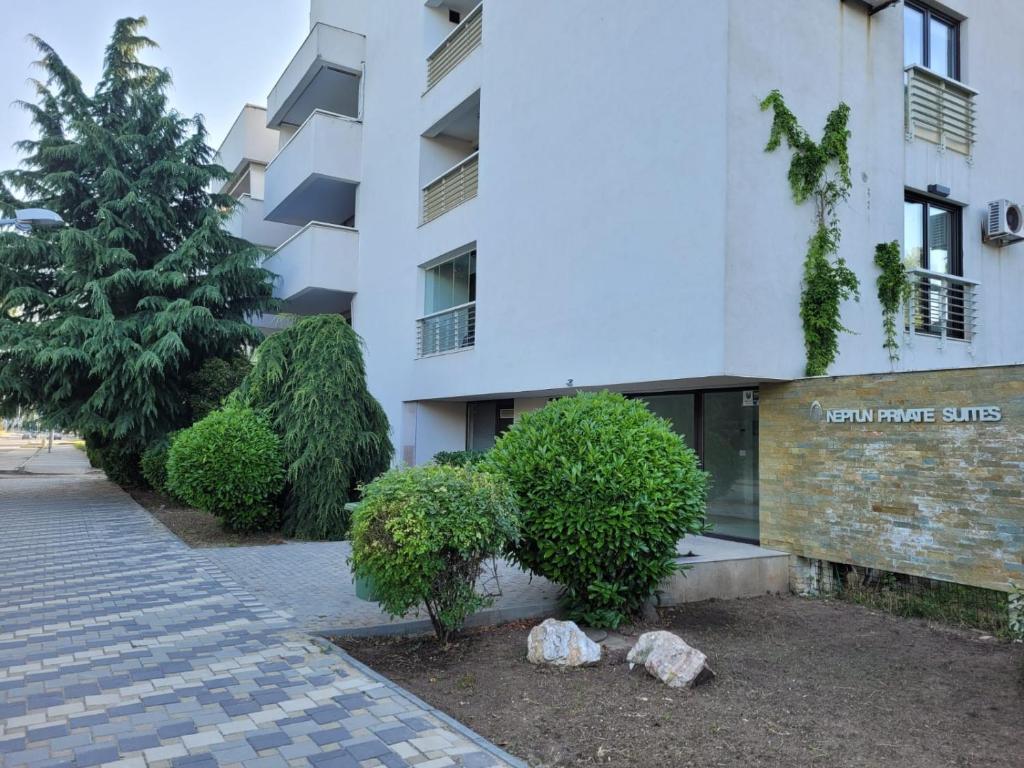 a building with trees and bushes in front of it at Sea Home Neptun in Neptun