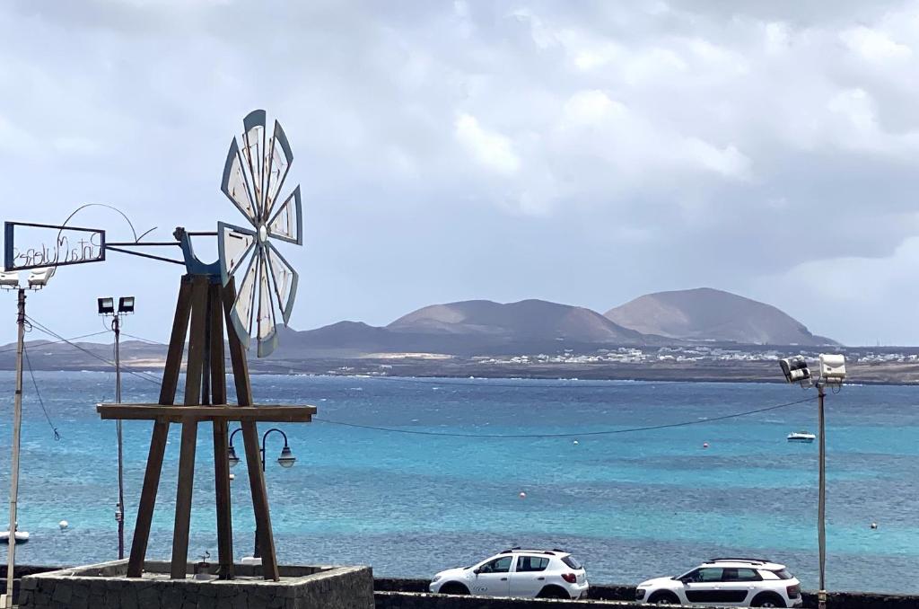 una estatua de un molino de viento junto a un cuerpo de agua en BLANCA FRENTE AL MAR, en Punta Mujeres