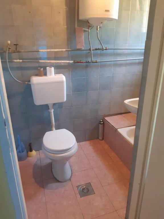 a bathroom with a toilet and a sink and a tub at Apartman Novi Sad - Apartment Novi Sad in Sremska Kamenica