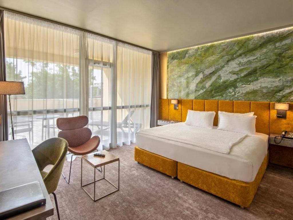 1 dormitorio con 1 cama y una gran pintura en la pared en Hotel Azur Premium, en Siófok