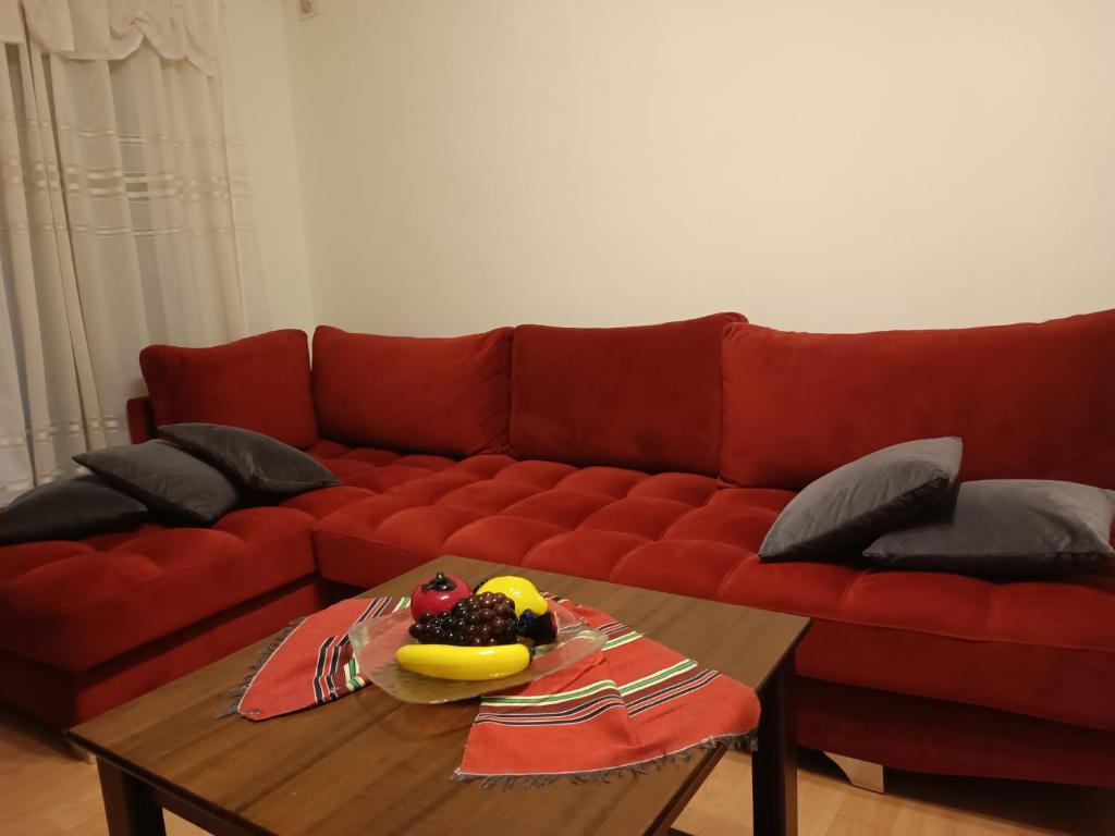 um sofá vermelho com uma mesa com fruta em Tirana's Hidden Wonder em Tirana