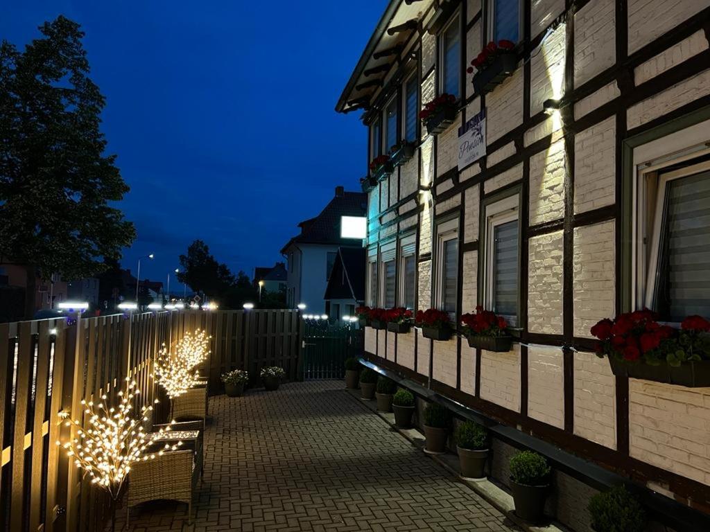 a fence with christmas lights next to a building at Pension Lavendel in Harztor