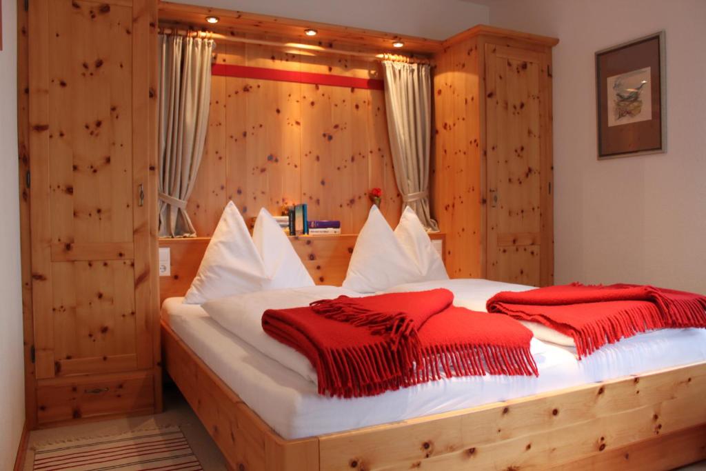 a bedroom with a wooden bed with two red blankets at Appartement Schöffmann in Bad Kleinkirchheim