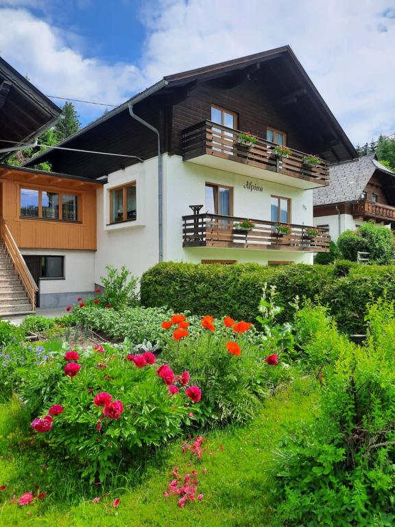 a house with flowers in front of it at Haus Alpina in Weissensee