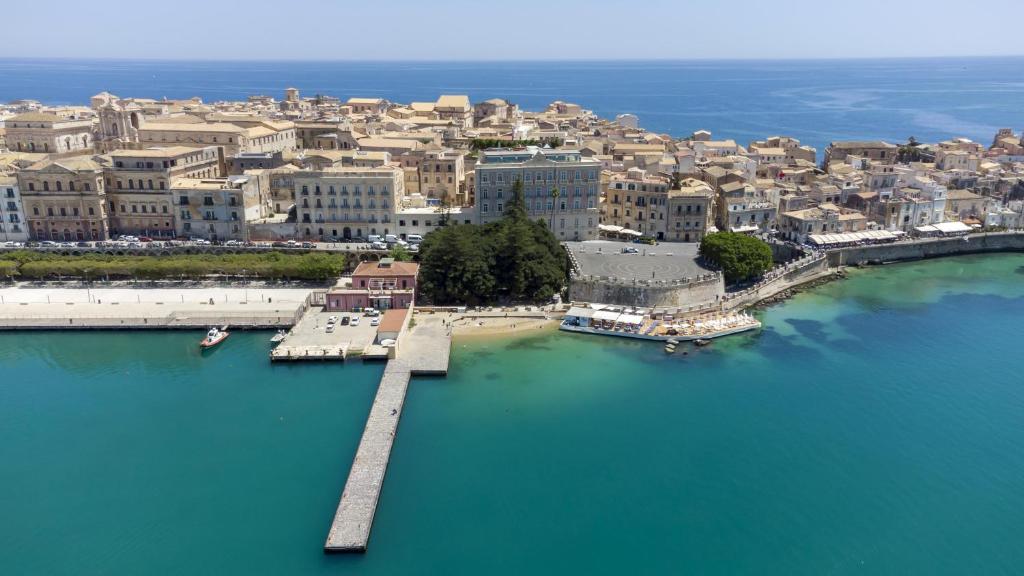 an aerial view of a city with a pier in the water at Grand Hotel Des Etrangers in Siracusa